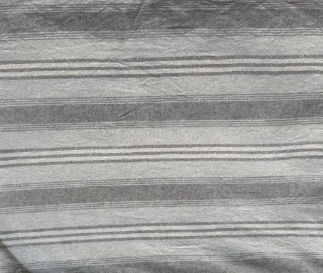 Tela con rayas en tonos grises y blancos, texturizada y suave.