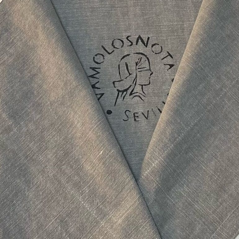 Tejido claro con un logo estampado que dice "Vamolosnota Sevilla".
