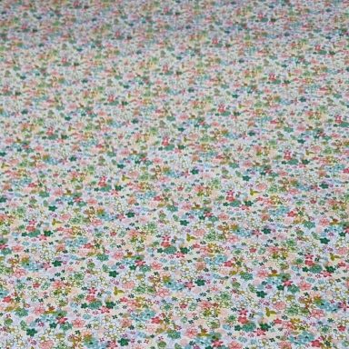 Fondo blanco con un patrón de pequeñas flores en tonos rosa, verde y azul.